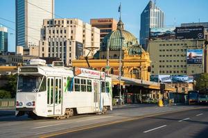 melbourne, australia - 20 febbraio 2016 - il tram del cavo passa la stazione di flinders street un'iconica stazione ferroviaria nel centro di melbourne, australia. foto