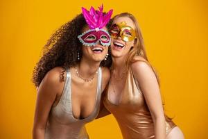 belle donne vestite per la notte di carnevale. donne sorridenti pronte a godersi il carnevale con una maschera colorata. foto