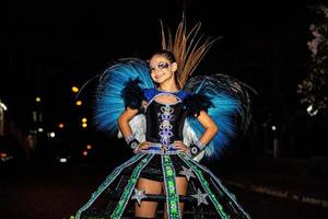 adolescente brasiliano che indossa un costume da samba. bella donna brasiliana che indossa un costume colorato e sorridente durante la parata di strada di carnevale in brasile. foto