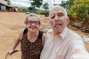 coppia di anziani agricoltori che scattano foto con lo smartphone.