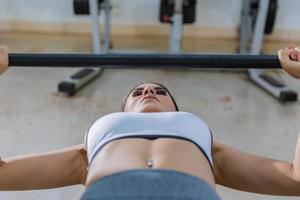 ragazza che si allena con la panca in una palestra foto