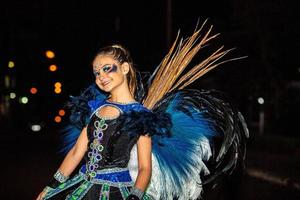 adolescente brasiliano che indossa un costume da samba. bella donna brasiliana che indossa un costume colorato e sorridente durante la parata di strada di carnevale in brasile. foto