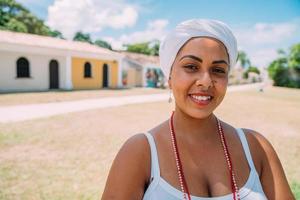 felice donna brasiliana vestita con il tradizionale costume bahiano che balla nel centro storico di porto seguro. concentrarsi sul viso foto