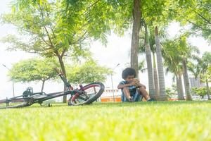 ragazzo seduto accanto a una bicicletta foto