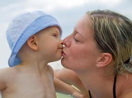 madre che bacia il suo bambino foto
