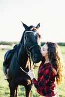 cavallo nero baciato da una giovane donna. foto