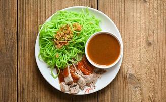 jade noodle asiatico cibo tailandese, anatra arrosto con jade noodle su piatto bianco e salsa d'anatra, spaghetti verdi cibo cinese foto