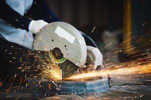 taglio di un acciaio con schizzi di scintille. industria siderurgica e concetto di officina. foto