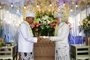 bandung, west java, indonesia, 2021- sposo e sposa musulmani durante una tradizionale cerimonia nuziale indonesiana. foto