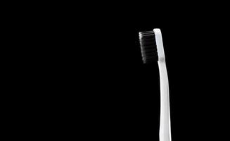 spazzolino grigio con setole nere su sfondo nero foto