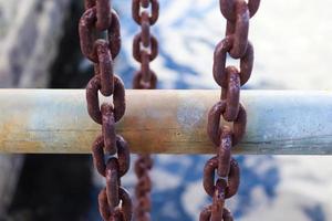 catena arrugginita attorno a sbarre di metallo nel porto di kiel. foto