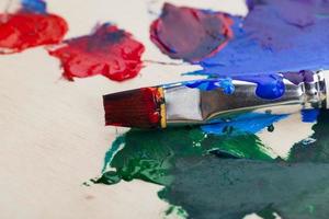un pennello artistico e vari tipi di vernice foto