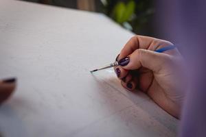 la donna adulta che dipinge con numeri, colori pastello, disegna su tela foto