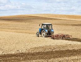 un vecchio trattore ara il terreno foto