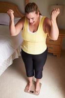 donna sovrappeso che si pesa sulle scale in camera da letto foto