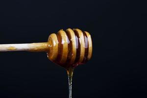 miele dolce denso e delizioso corrente, primo piano foto