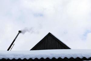 camini sul tetto di un edificio in inverno foto