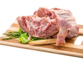 agnello crudo su piatto di legno e sfondo bianco foto