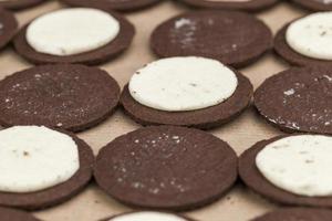 biscotti al cioccolato con ripieno di crema cremosa foto