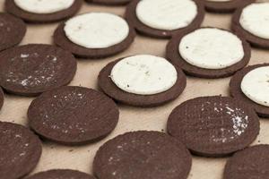 biscotti al cioccolato con ripieno di crema cremosa foto