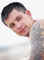 Ritratto di giovane uomo con tatuaggio sul braccio (avambraccio) foto