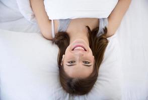 donna allegra sdraiata sul letto foto