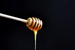 un cucchiaio per il miele insieme a miele d'api di alta qualità foto