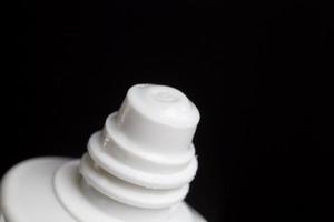 parte sigillata di un tubo di plastica di colore bianco e cosmetico foto