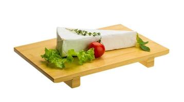 brie con timo su piatto di legno e sfondo bianco foto