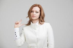 donna in giacca bianca che punta un dito