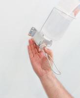 mano usando il distributore di pompa gel disinfettante per le mani foto