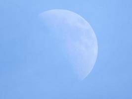 mezza luna nel cielo blu durante il giorno foto