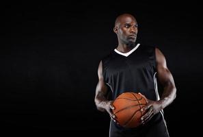 giocatore di basket muscoloso su sfondo nero foto