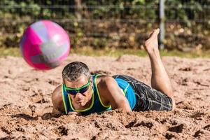beachvolleyballer sdraiato nella sabbia foto