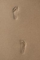 due impronte umane nella sabbia bagnata