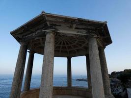 classica rotonda in pietra di fronte al mare sul sentiero costiero di s'agaro, catalogna, spagna foto