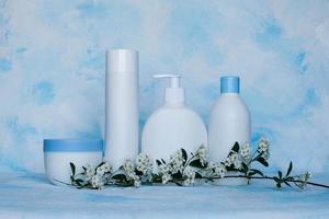 un set di contenitori bianchi, di plastica. packaging, dima per flacone per cosmetici, antisettico, con detersivi e detergenti chimici, per prodotti medicali e cosmetici. sfondo bianco e blu foto