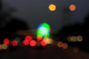 bellissimo sfondo di luci bokeh di notte su strada con auto foto