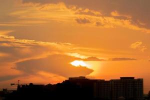 dà una calda sensazione, il tramonto dietro l'edificio della città, gli edifici alti della città silhouette, la silhouette della costruzione di nuovo il bellissimo sfondo del cielo e il concetto di libertà. foto