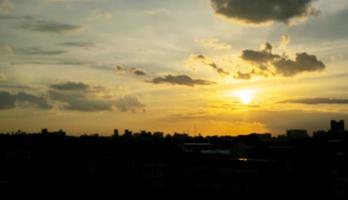 dà una calda sensazione, il tramonto dietro l'edificio della città, gli edifici alti della città silhouette, la silhouette della costruzione di nuovo il bellissimo sfondo del cielo e il concetto di libertà. foto