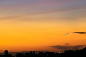 dà una calda sensazione, il tramonto dietro l'edificio della città, gli edifici alti della città silhouette, la silhouette della costruzione di nuovo il bellissimo sfondo del cielo e il concetto di libertà. foto