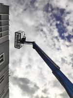 gru manlift con piattaforma di sollevamento sul tetto di un edificio foto