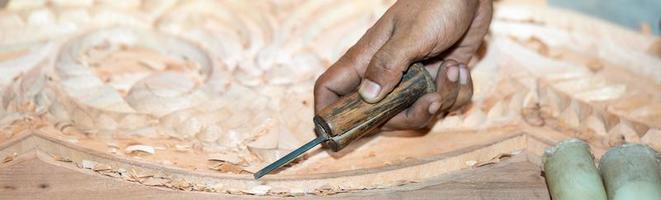 la mano dell'uomo del carpentiere del primo piano tratta l'albero, taglia i trucioli. copia spazio. ricciolo legnoso. lavorazione manuale del legno in officina. falegname in lavorazione. foto