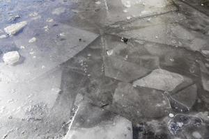 ghiaccio grigio sporco sulle pozzanghere foto