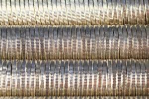 molte monete metalliche rotonde di colore argento illuminate in rosso foto