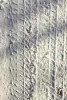 l'impronta delle ruote dell'auto sulla neve da vicino foto
