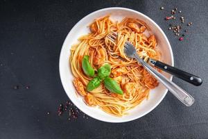spaghetti pasta pollo salsa di pomodoro fresco pasto sano cibo spuntino dieta sul tavolo copia spazio cibo sfondo rustico vista dall'alto foto