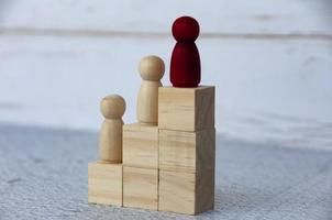 figura rossa di legno che guida gli altri in cima a blocchi di legno. concetto di leadership. foto