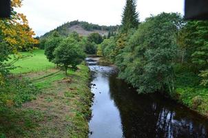 bella campagna panoramica in Scozia con un fiume che scorre foto