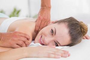 Fisioterapista che fa massaggio alla spalla foto